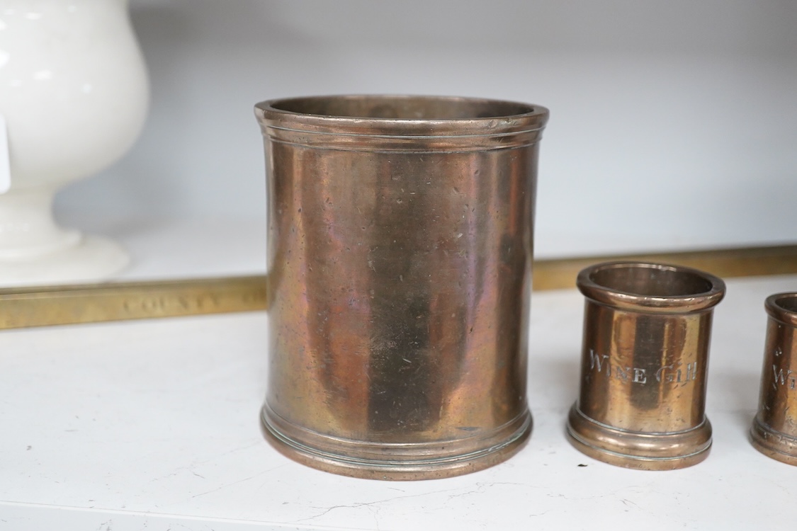 Three 19th century bell metal wine gill measures, two smaller examples engraved; ‘wine hill’, tallest 13.5cm